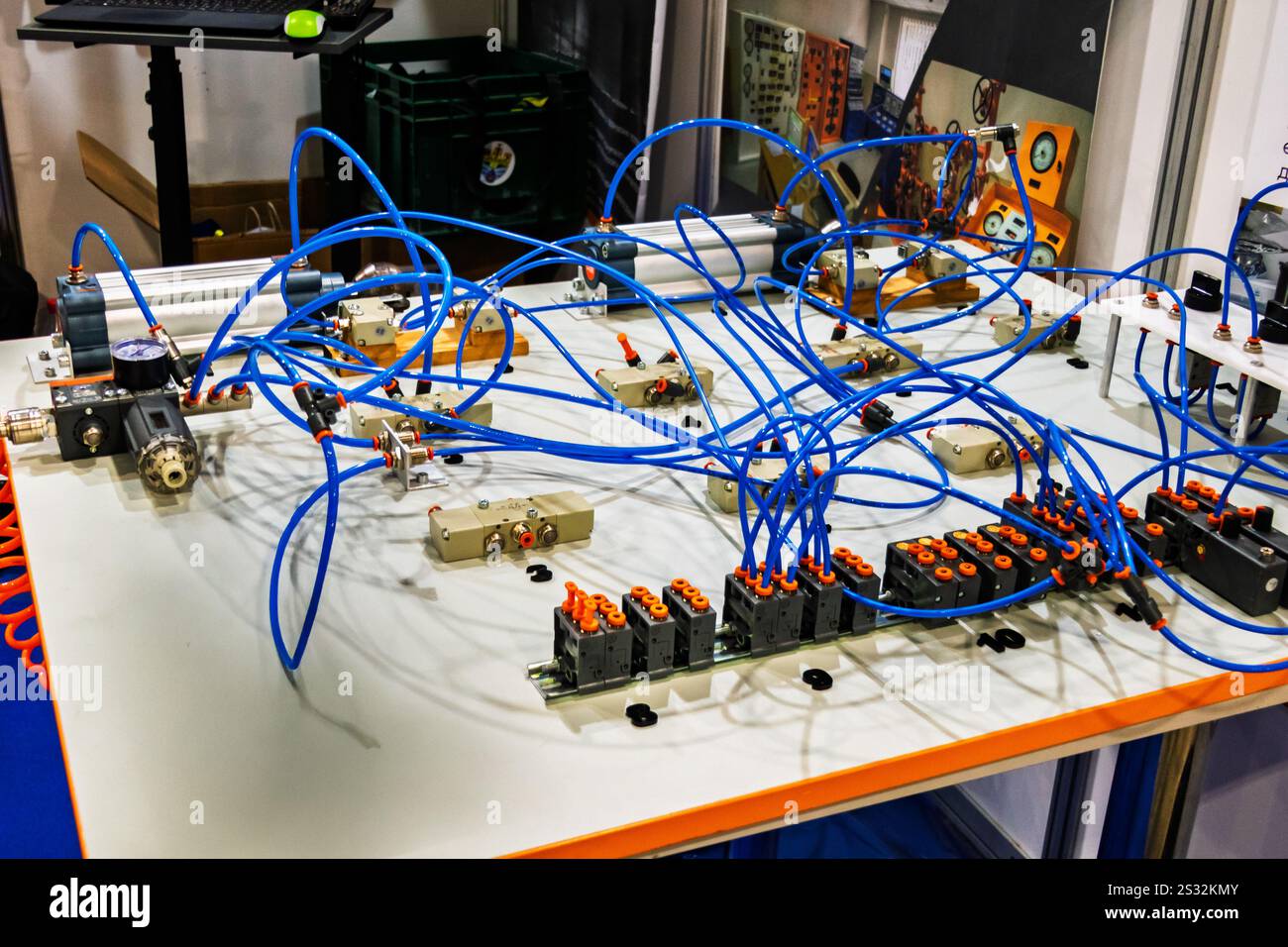 A close-up of a hydraulic training rig with numerous blue hoses and ...