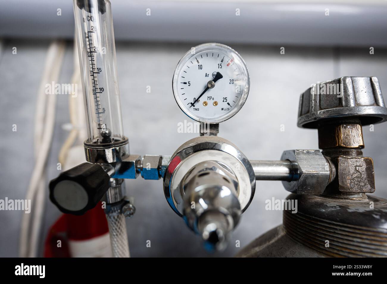 A detailed view of a pressure gauge attached to metal equipment ...