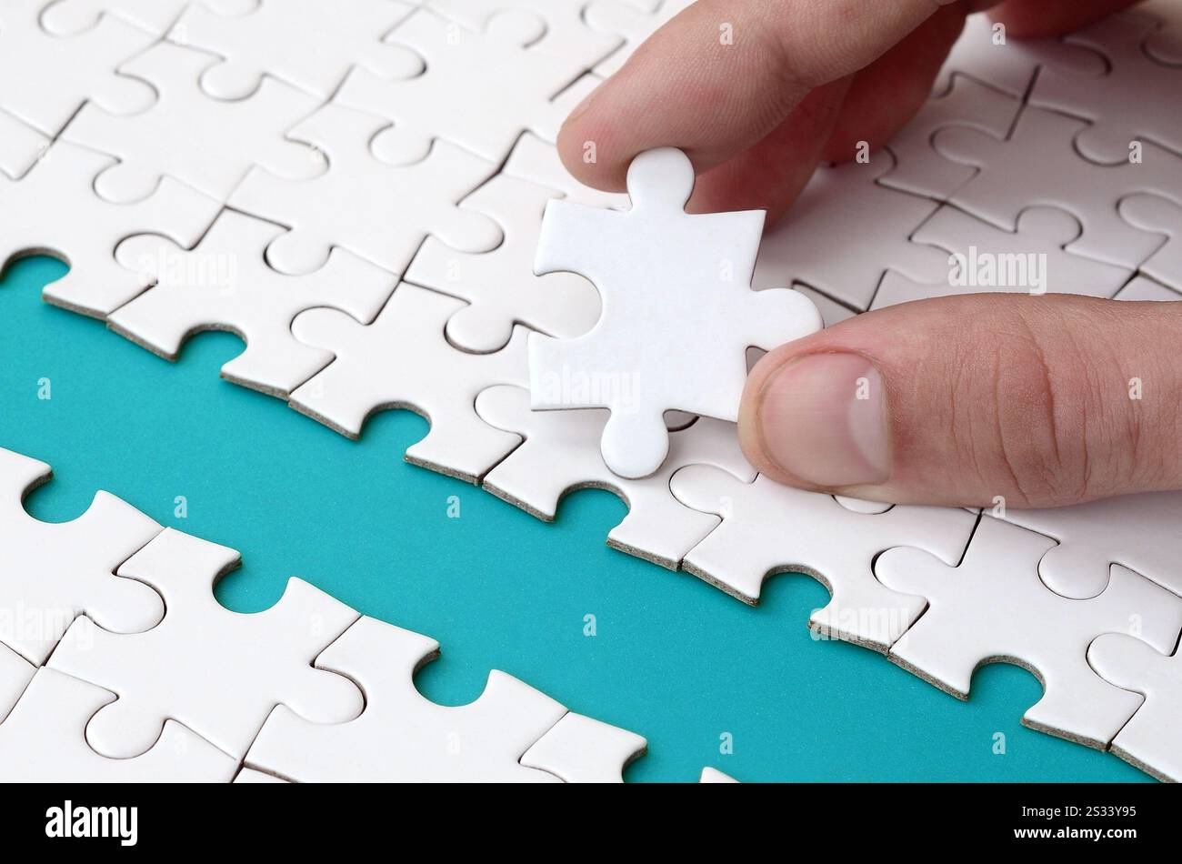 The human hand paves the way to the surface of the jigsaw puzzle The human hand paves the way to the surface of the jigsaw puzzle