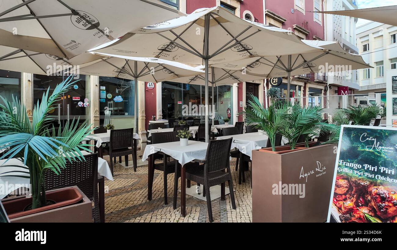 Empty outdoor patio seating at a café in Faro, Portugal, during the winter low tourist season. Stock Photo