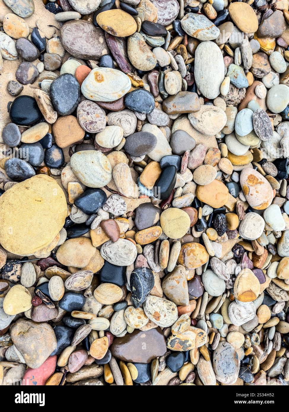 close up of multi coloured pebbles on the stony beach at Blyth South Beach Northumberland UK background image - Smartphone Captured Stock Image