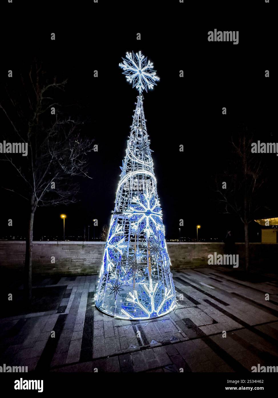 Illuminated Christmas tree at night with blue LED lights and large snowflake decorations, creating a festive holiday atmosphere Hanley stoke on Trent - Smartphone Captured Stock Image