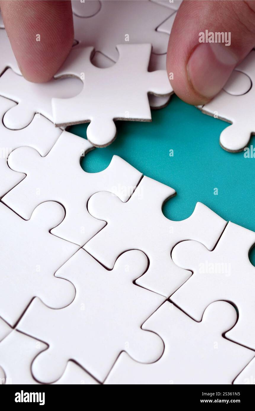 The human hand paves the way to the surface of the jigsaw puzzle The human hand paves the way to the surface of the jigsaw puzzle