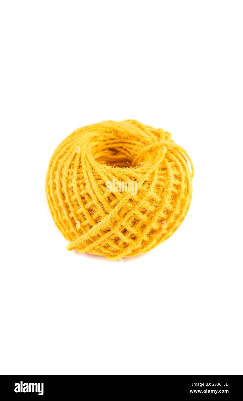A roll of yellow jute twine placed on a white background, ideal for crafting, packaging, and DIY projects. Perfect for online stores or product catalo Stock Photo