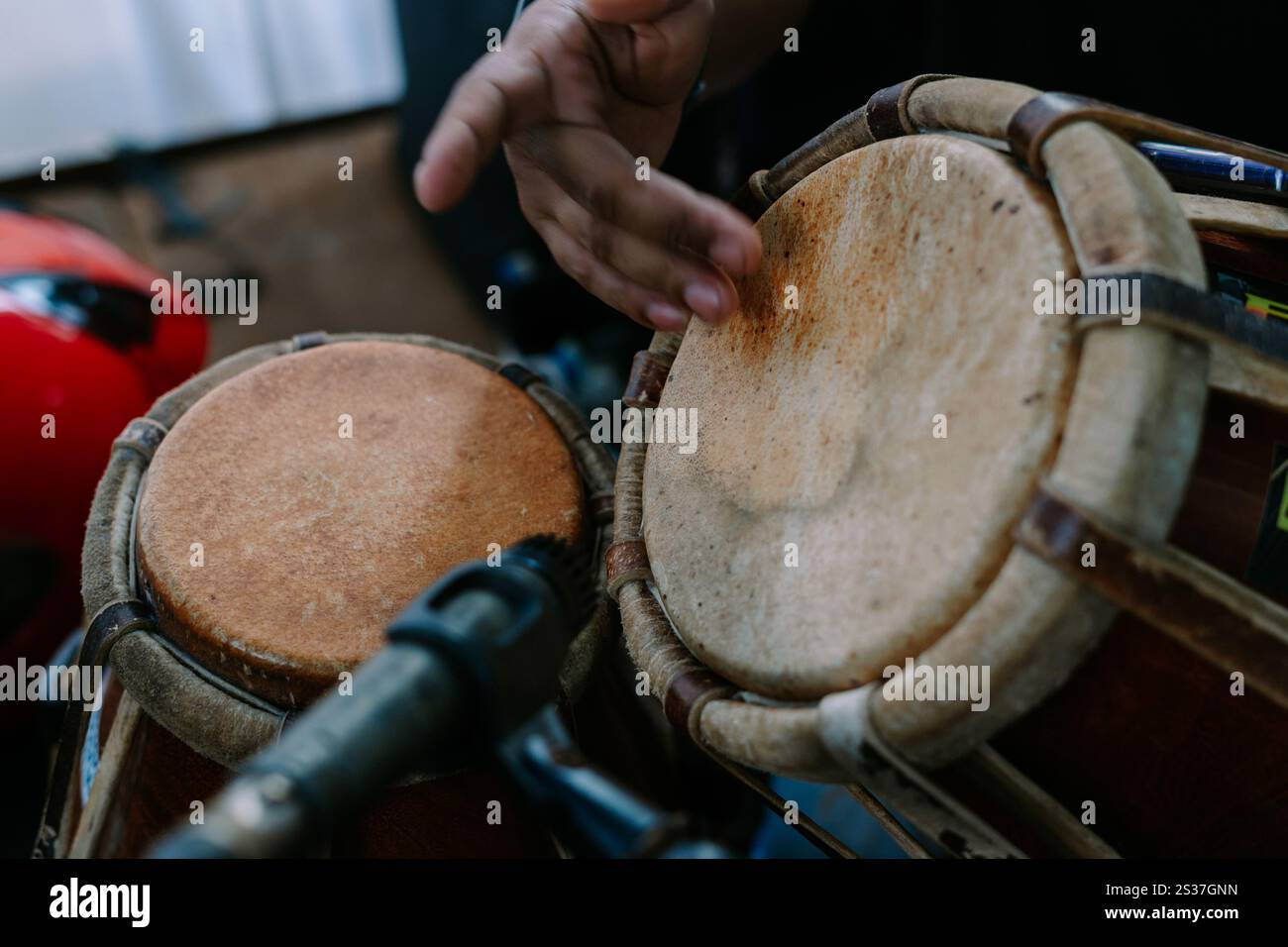 Close-up of hands playing traditional drums, creating a vibrant beat Stock Photo