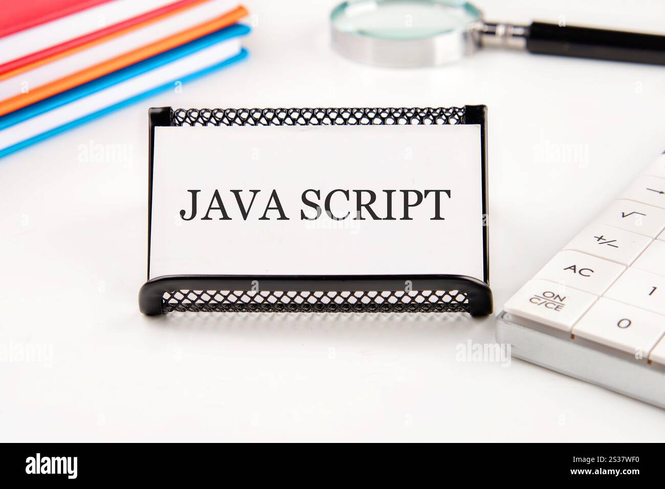 JavaScript displayed on a desk with a calculator, a notepad, and a ...