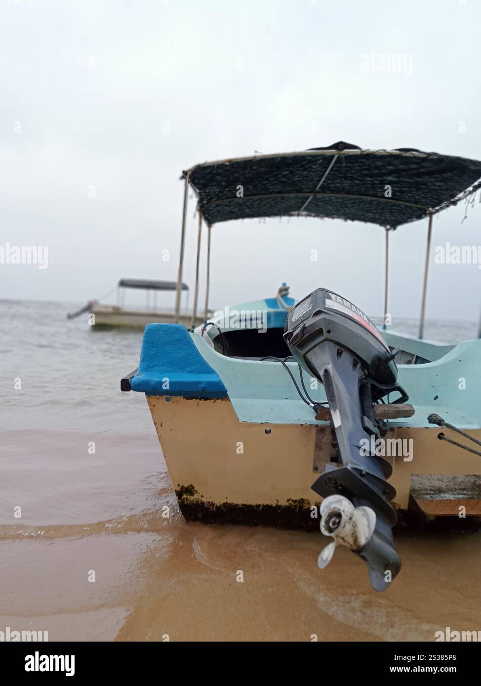 Small canopy motorized boat docked in the beach - Smartphone Captured Stock Image