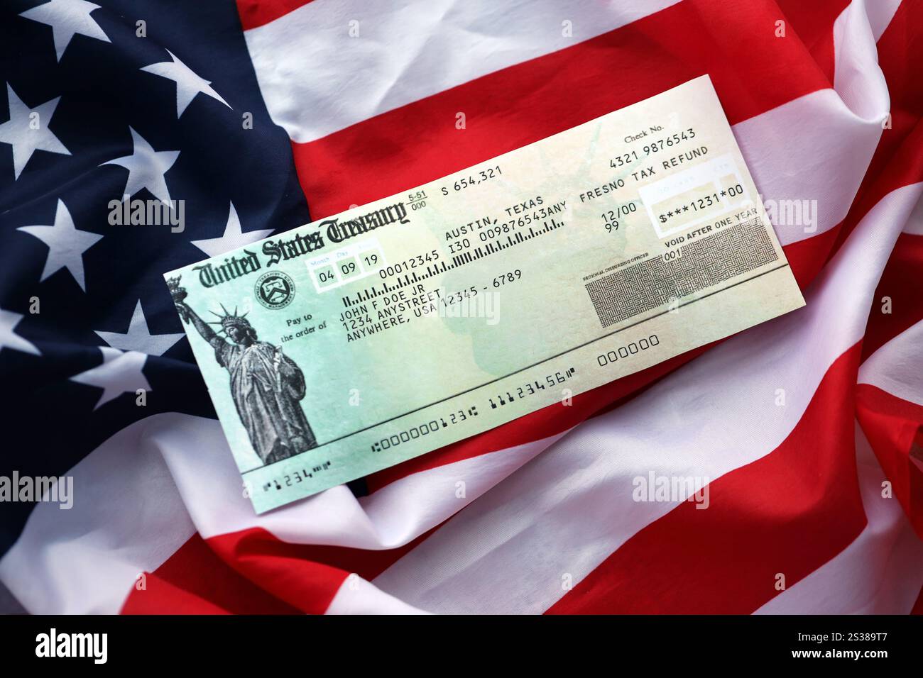 United states treasury refund check on waving american flag close up