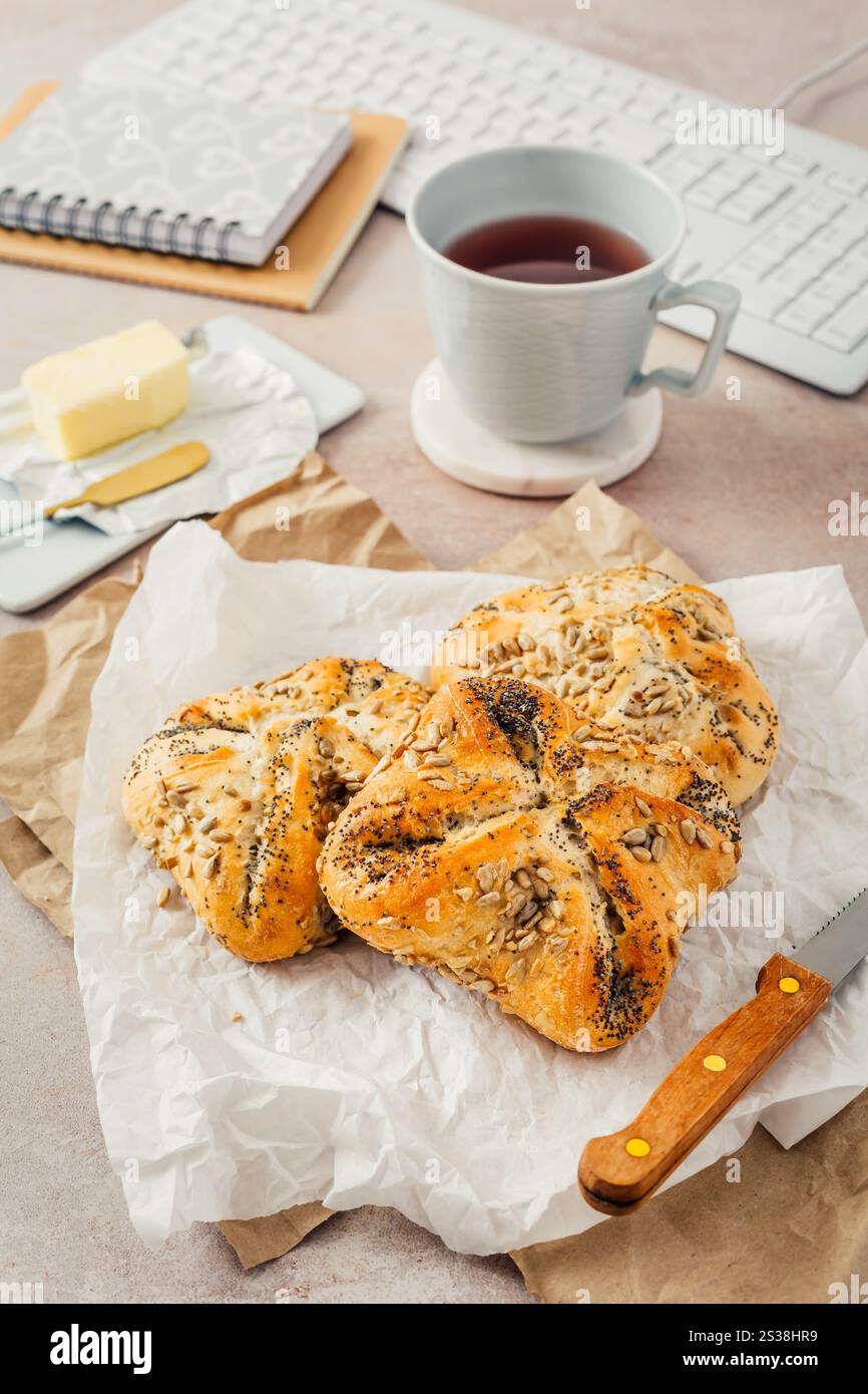 Lunch in a office, delicious bread rolls with butter and coffee on desktop Stock Photo
