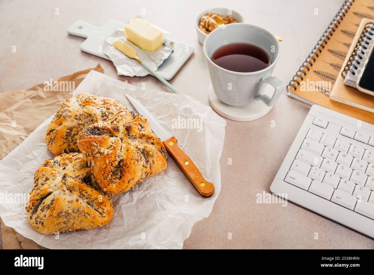 Lunch in a office, delicious bread rolls with butter and coffee on desktop Stock Photo