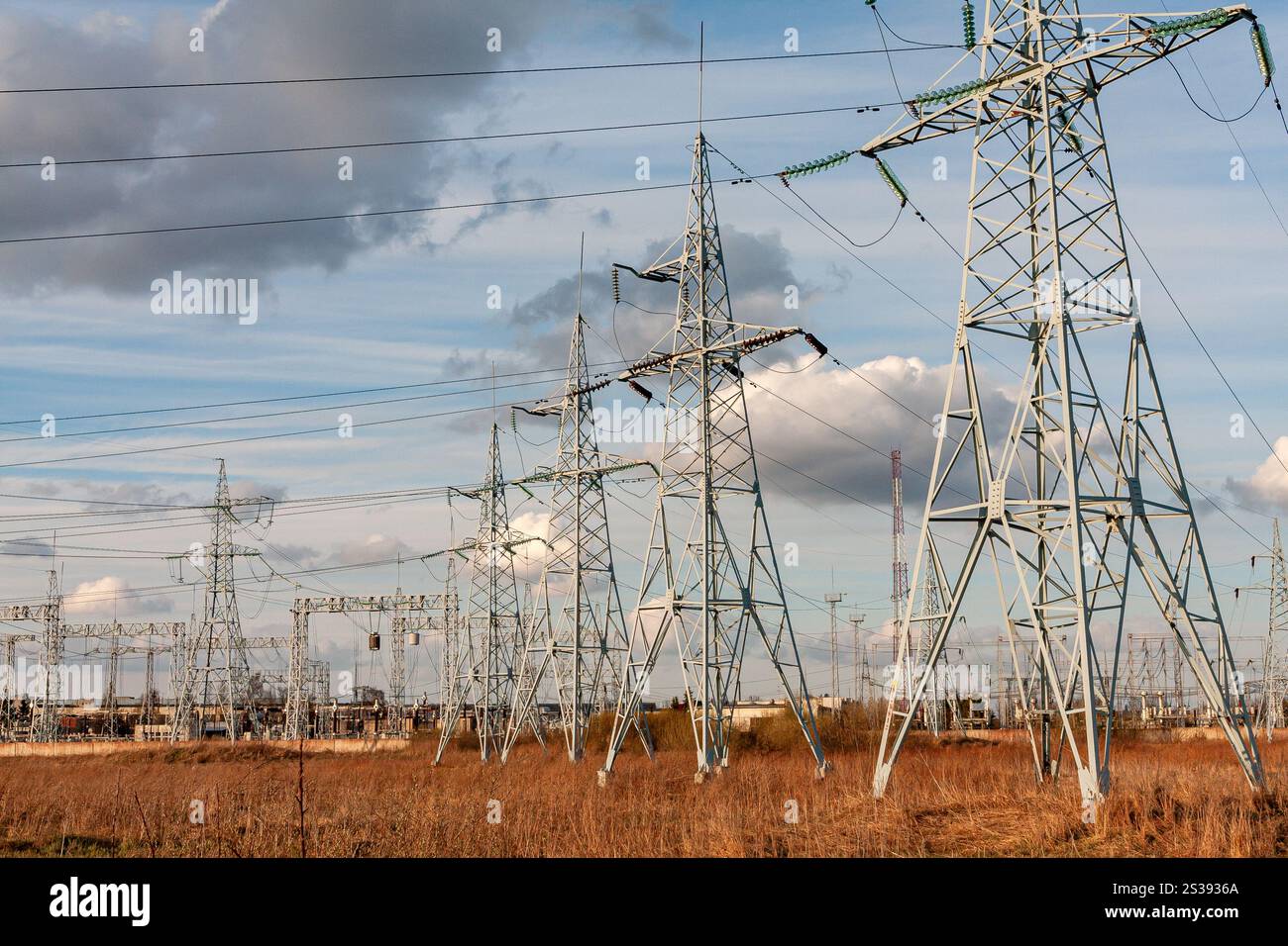 Power transmission pylons spanning across an open field under a clear ...