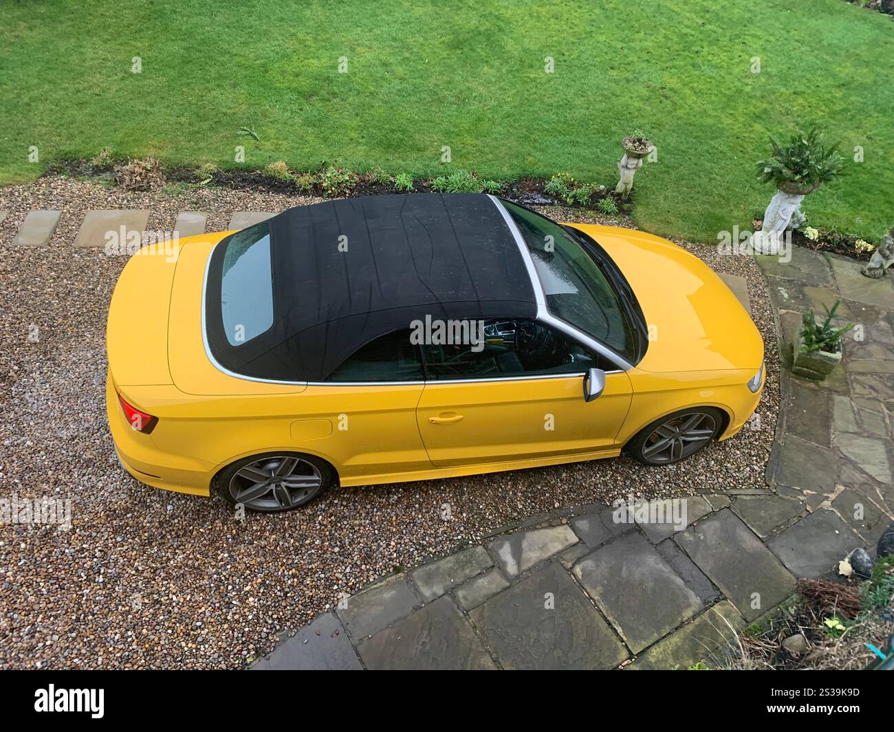 Yellow Sports car soft top black cloth roof rooftop view views sporty sports type fast sunny weather style ladies bright posh grass roof Audi - Smartphone Captured Stock Image