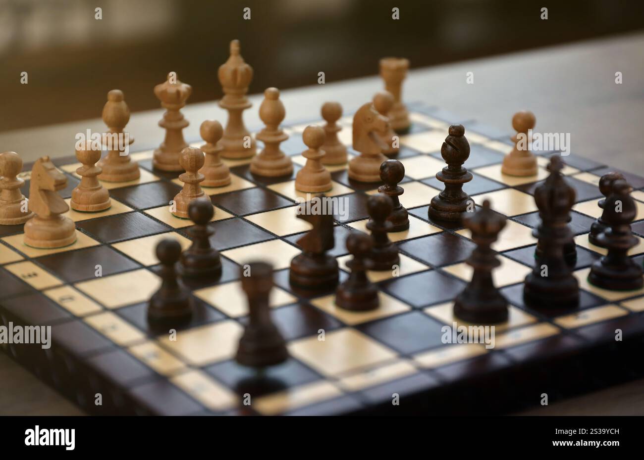 The chess board with the pieces in the dark vintage room interior. The ...