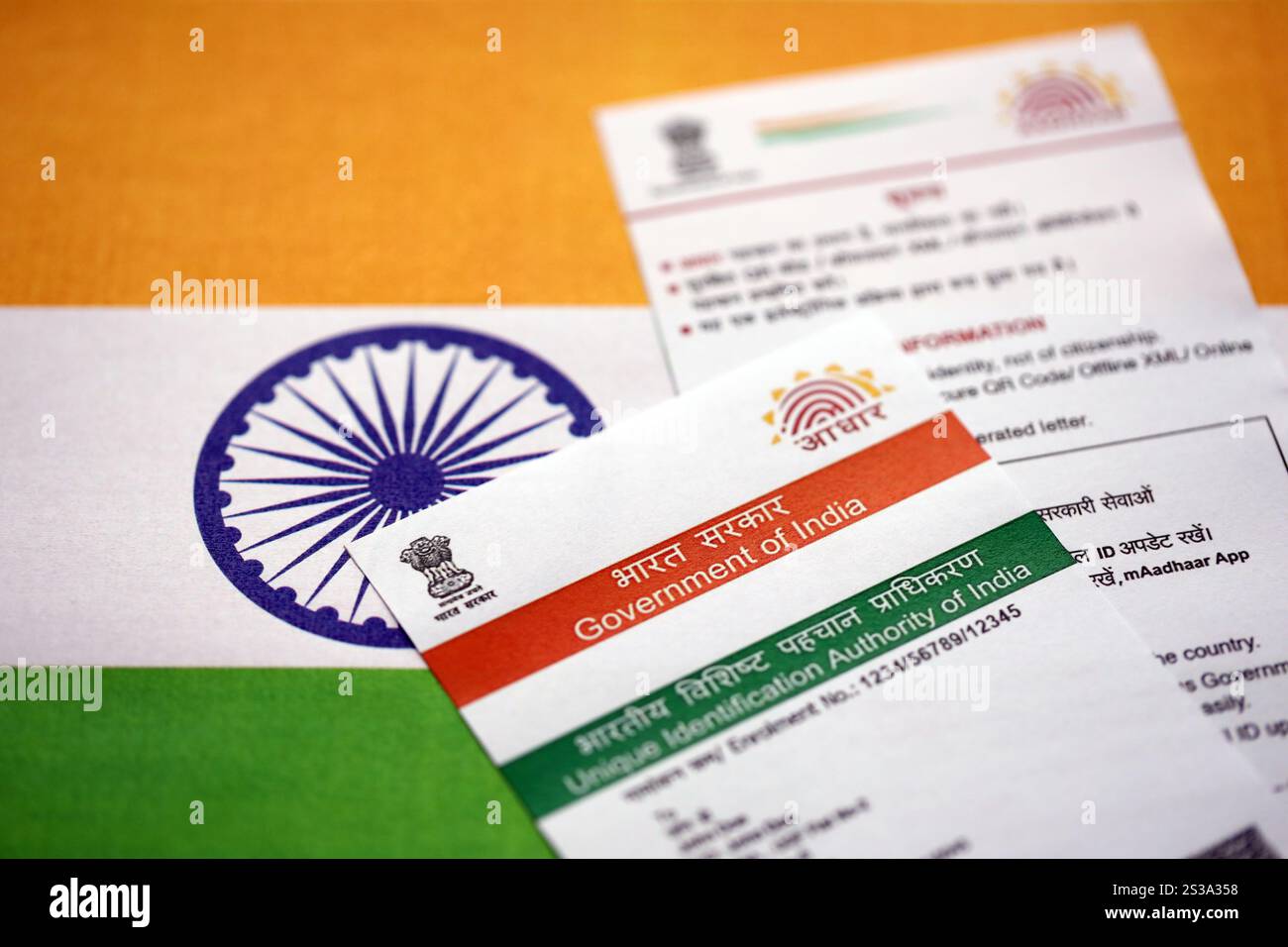 Indian Aadhaar card from Unique Identification Authority of India on Indian flag close up Stock Photo