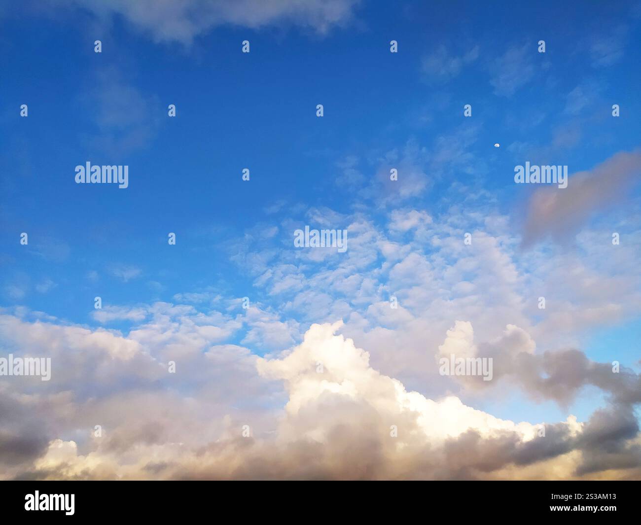 The sun is setting, casting a warm glow over the clouds in the sky. The ...