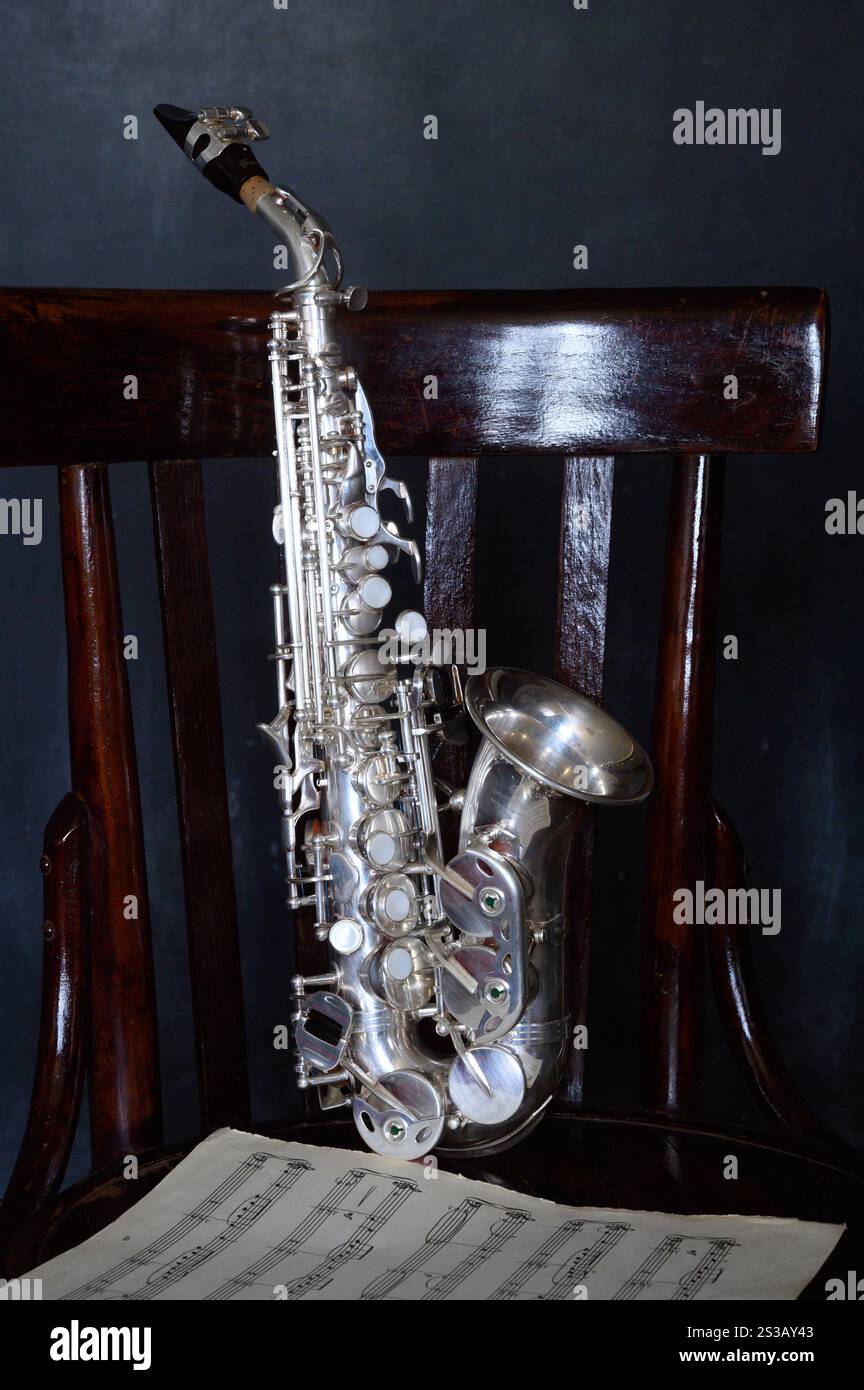 A silver saxophone on an old chair Stock Photo - Alamy