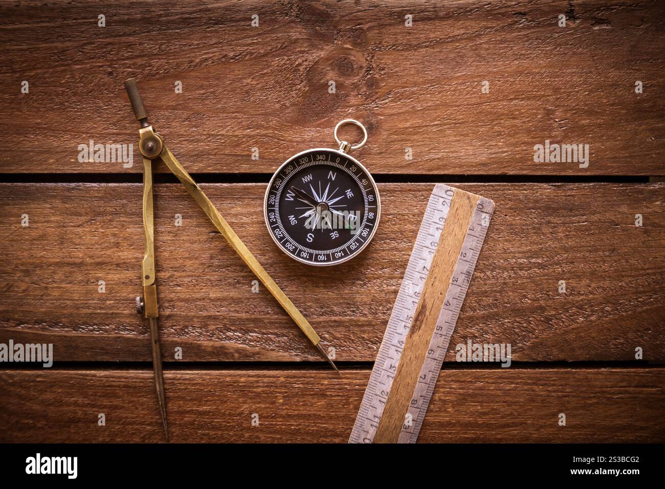 Vintage ruler, drawing and navigational Compass on a rustic wooden ...