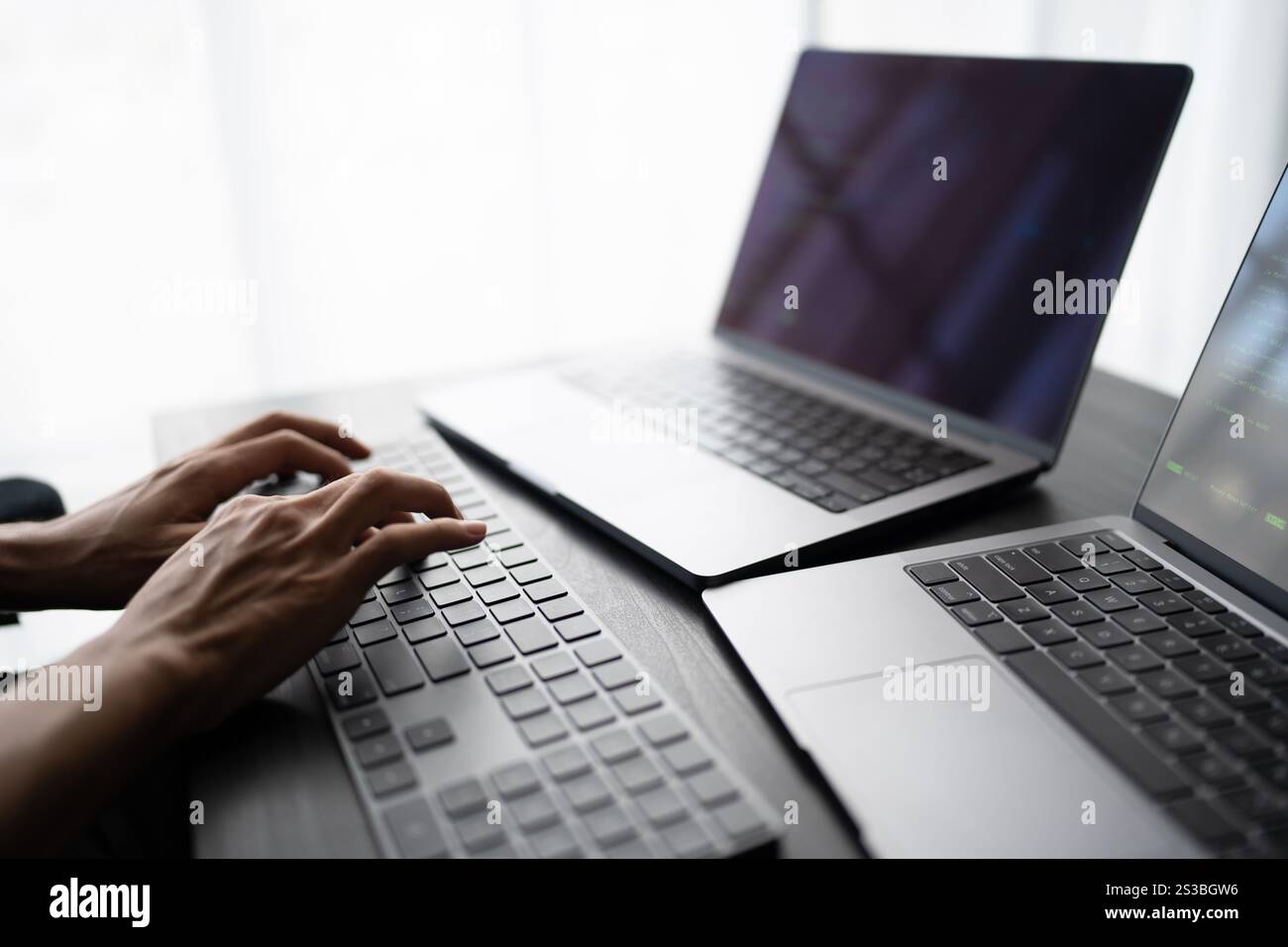 Asian man software engineer Working on Computer at office desk for writing program code IT Software Engineer finding errors tech support devops Stock Photo