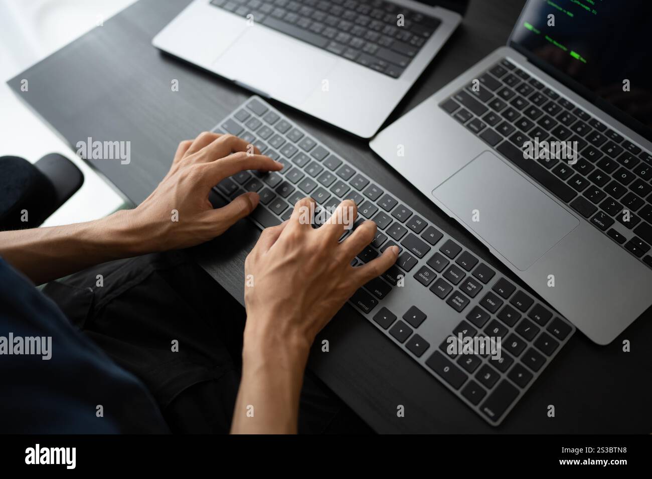 Asian man software engineer Working on Computer at office desk for writing program code IT Software Engineer finding errors tech support devops Stock Photo