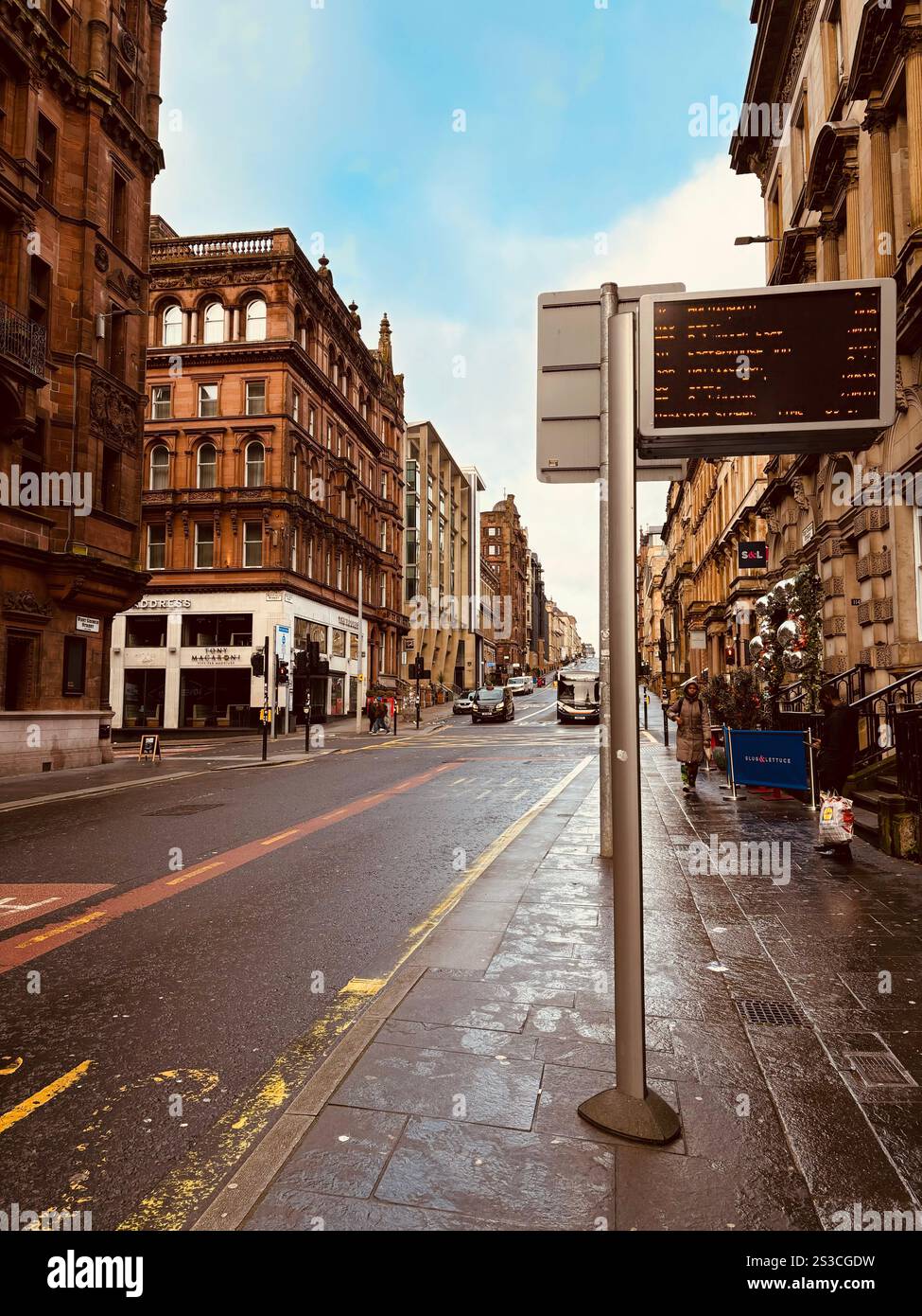A quiet moment on a Glasgow street, with a digital bus stop sign reflecting the city skyline. - Smartphone Captured Stock Image