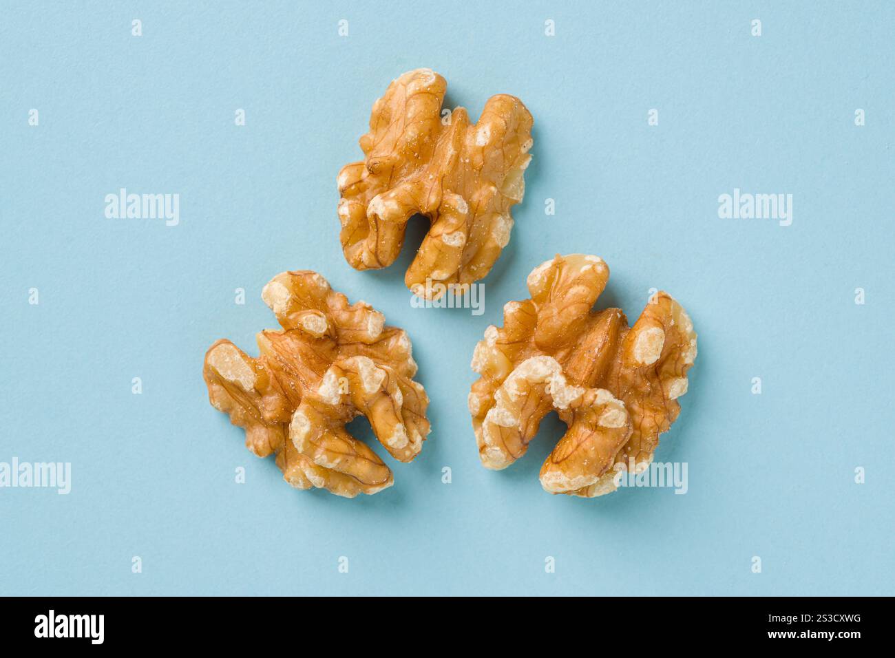 Top view of half walnut kernel on blue background Stock Photo