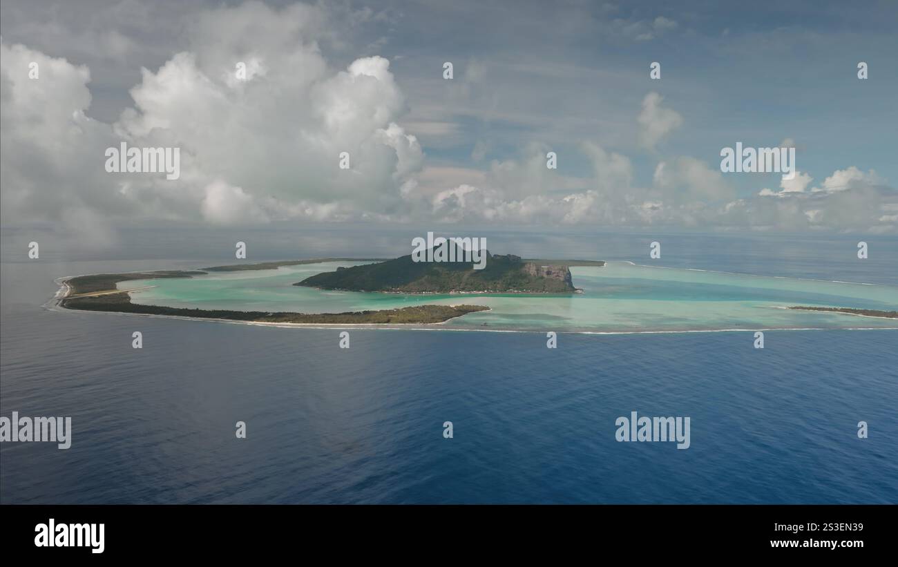 Volcanic mountain on Maupiti island in French Polynesia, surrounded by ...