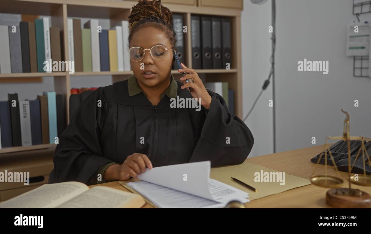 Judge Talking Judge talking on phone while reviewing documents in an office, wearing ...