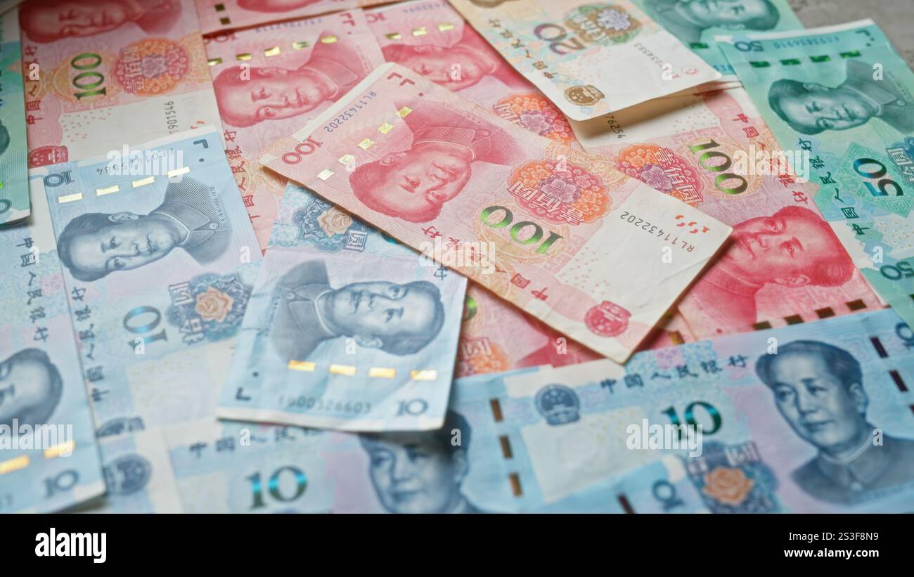 Chinese yuan banknotes scattered on a surface showcasing various ...