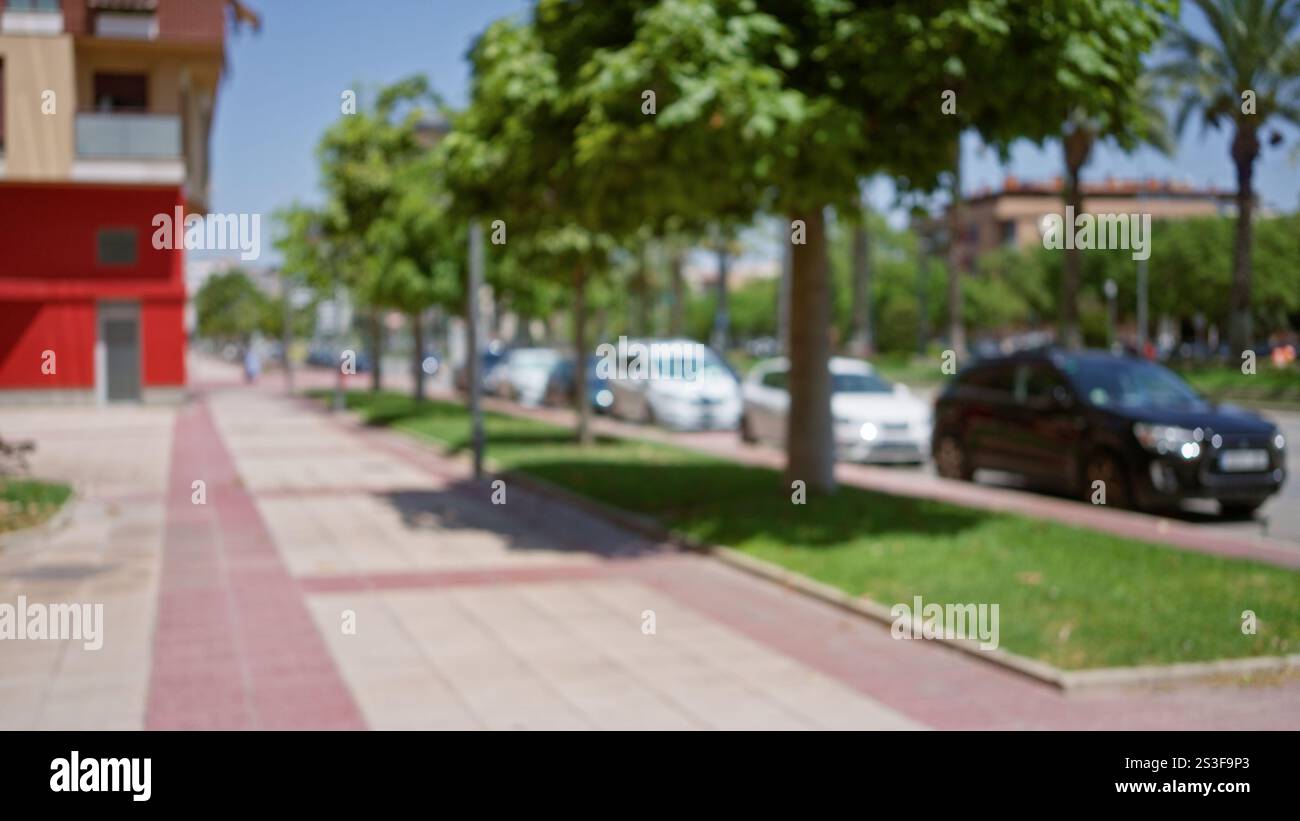 Urban street with blurred cars, sidewalk, and trees in an outdoor ...
