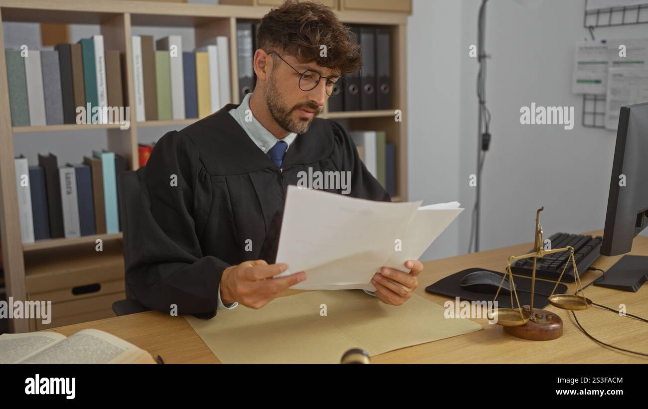 Young man in a judge's robe reading documents in an office with a scale ...