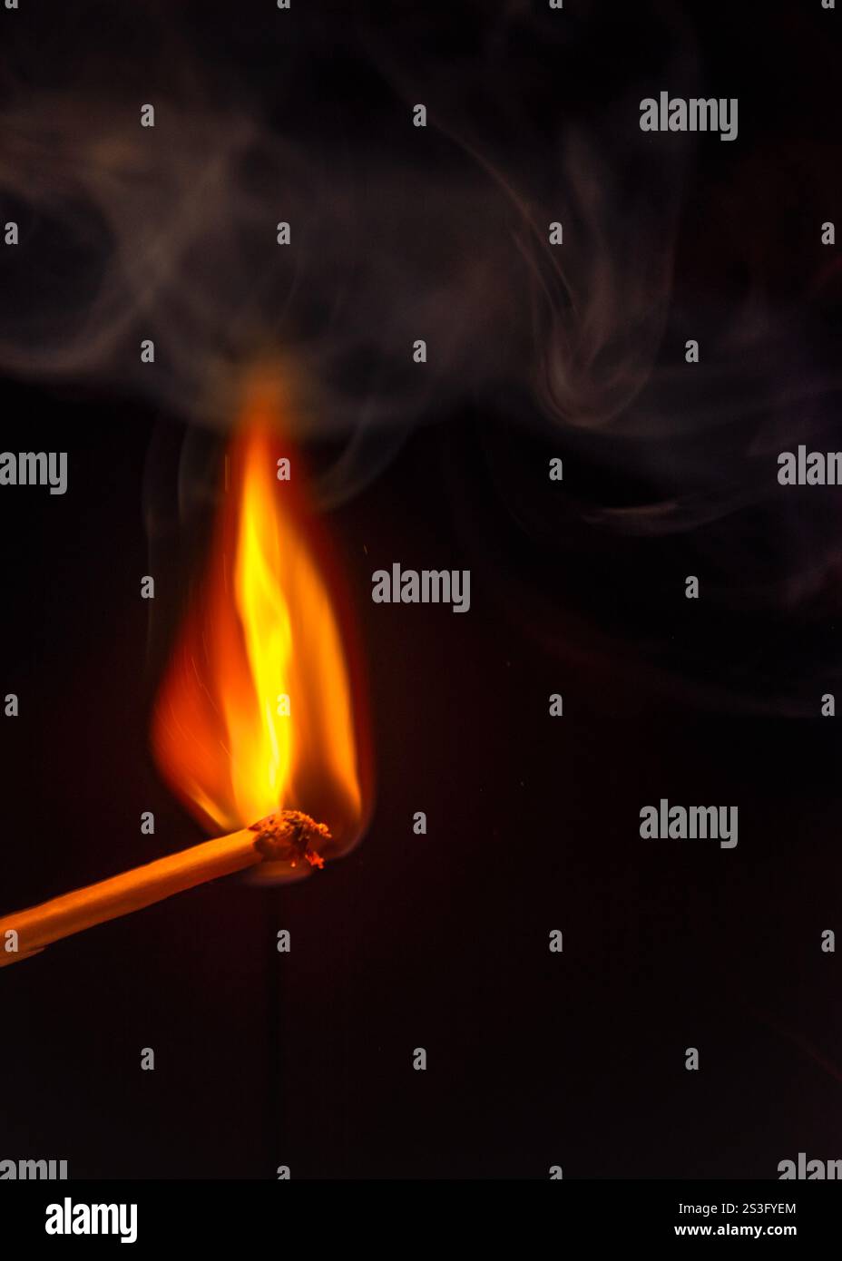 burning matchstick with some smoke on black background Stock Photo