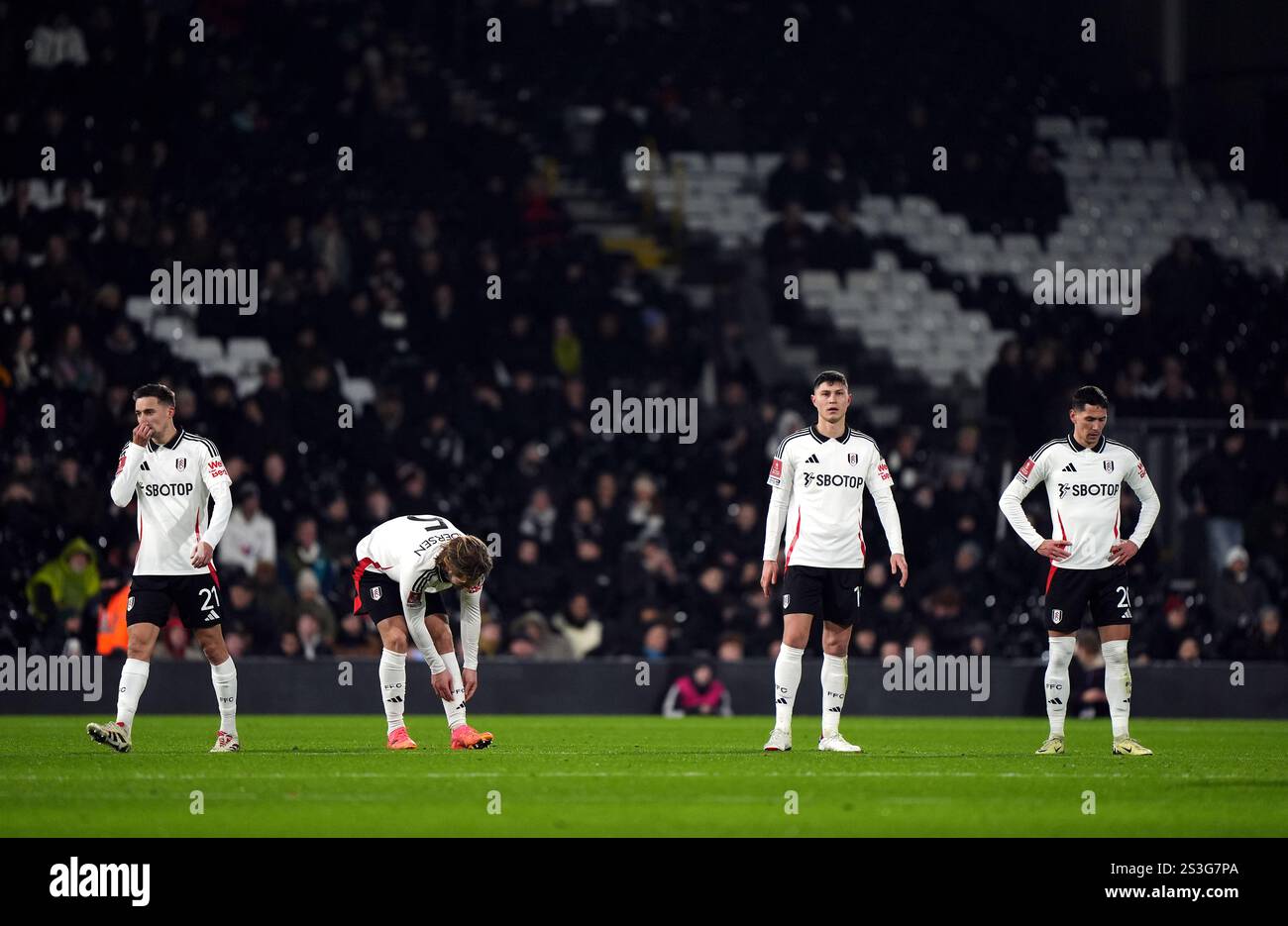 Fulham players react after they concede their first goal during the