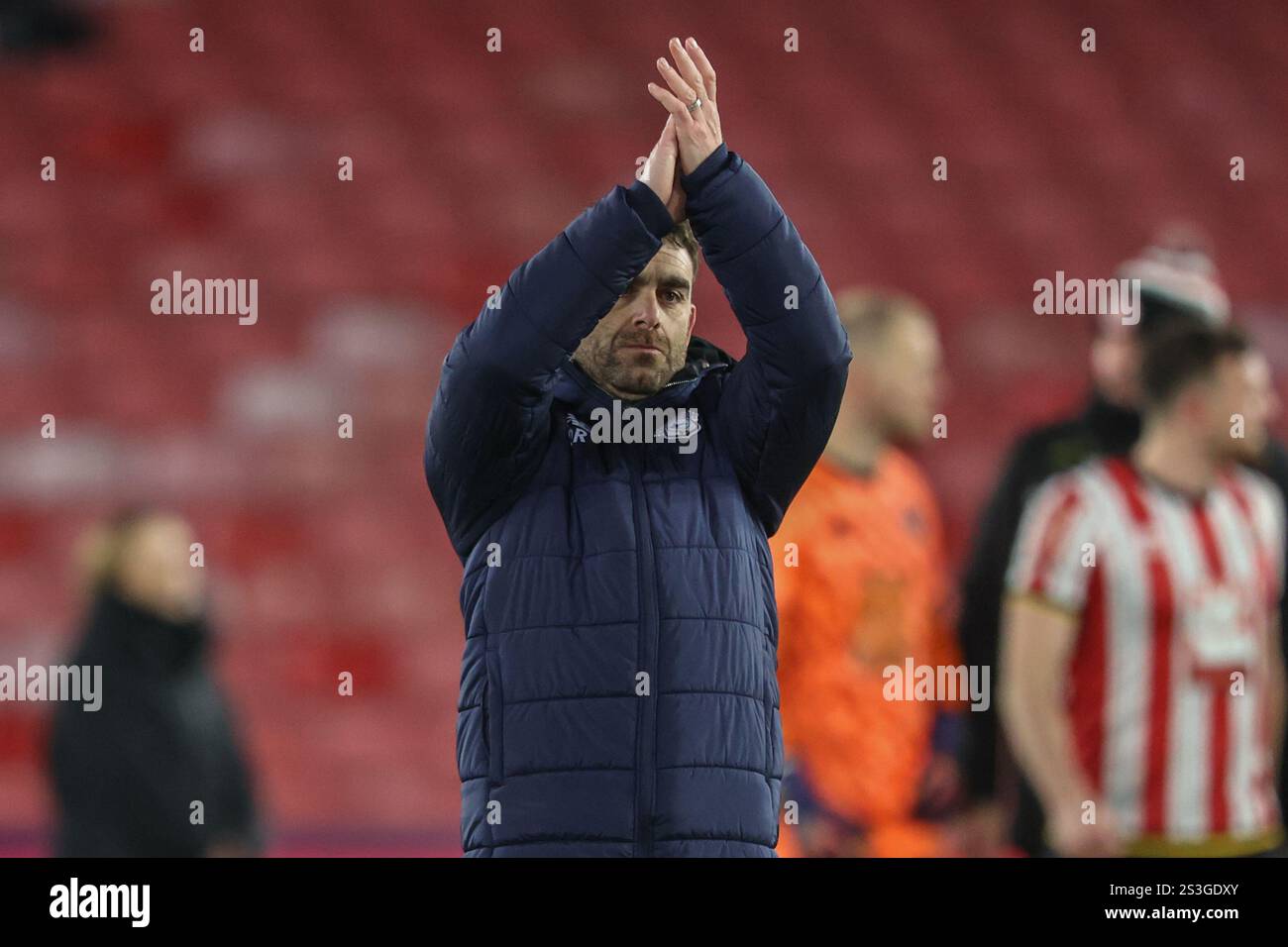 Ömer Riza manager of Cardiff City applauds the fans after the game
