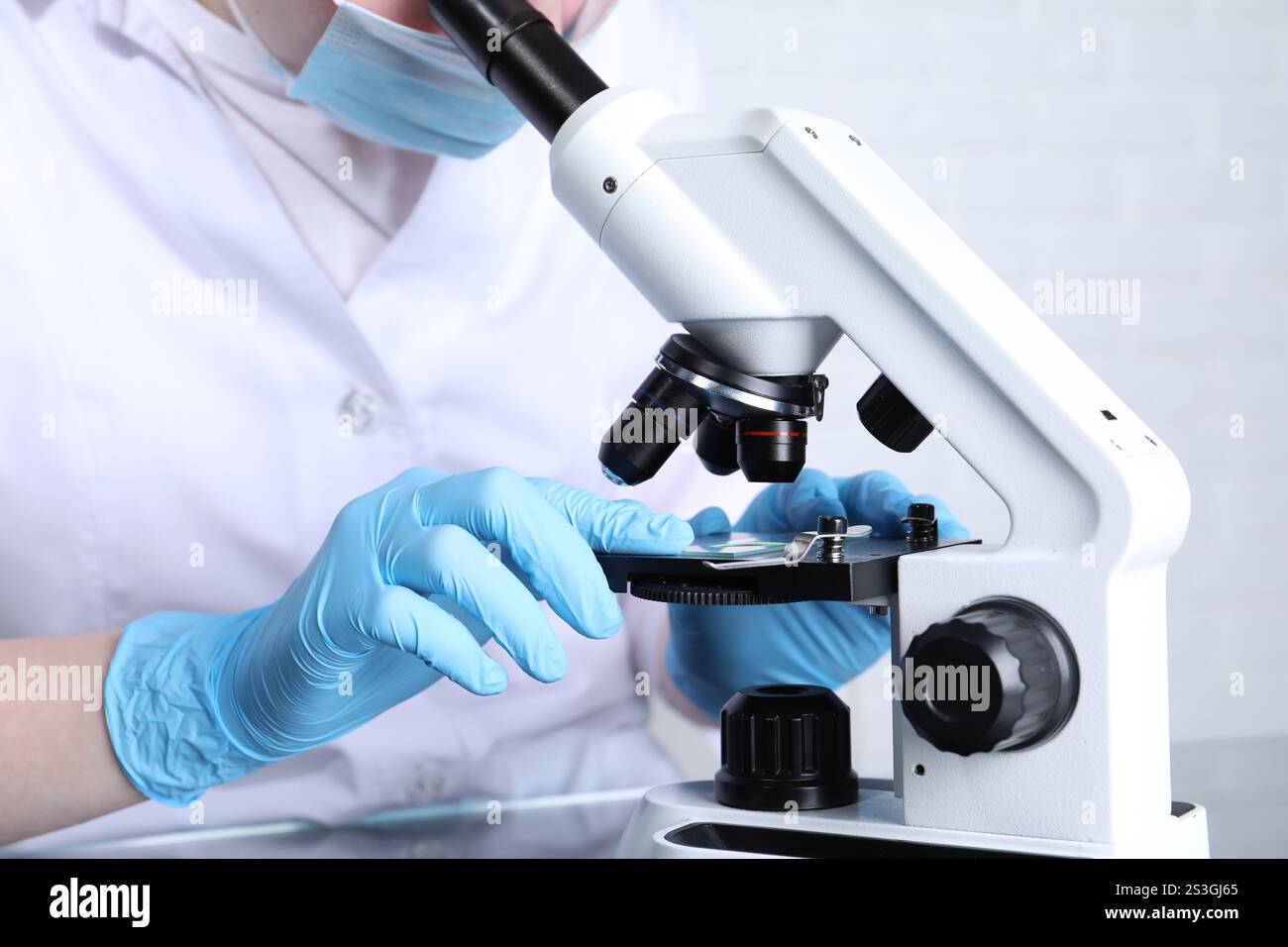 Laboratory testing. Scientist examining sample on slide under ...