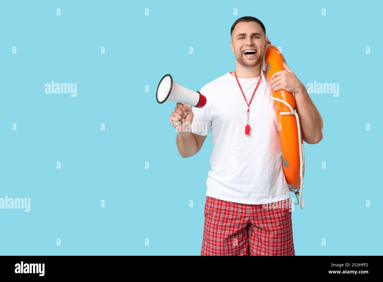 Happy young lifeguard with lifebuoy and megaphone on blue background Stock Photo - Alamy