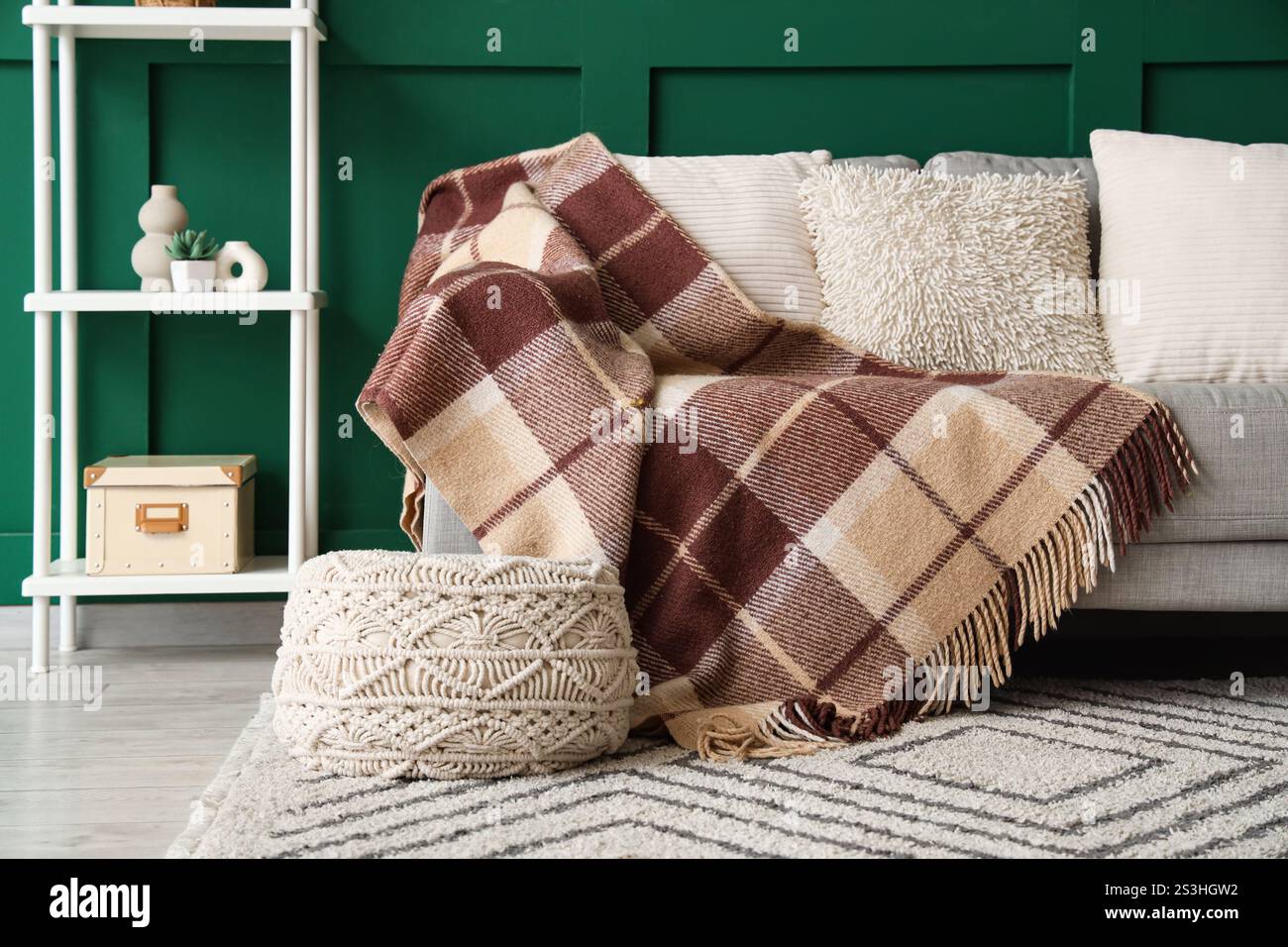 Interior of living room with sofa and knitted blanket Stock Photo
