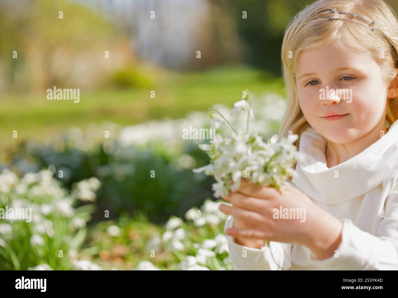 Young girl holding a bunch of white flowers Stock Photo - Alamy