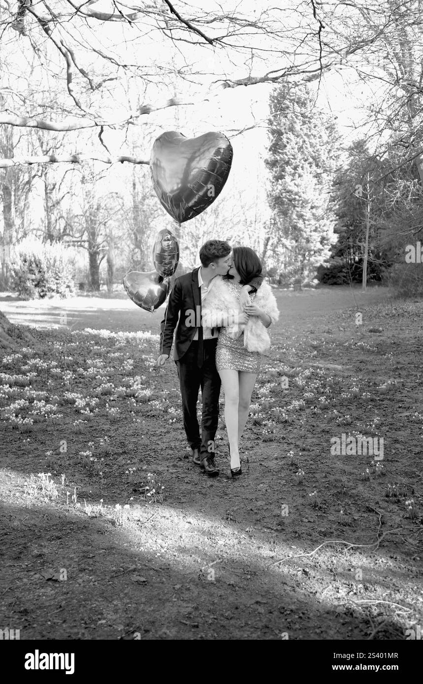 Young Couple Kissing in Park Holding Heart Shaped Balloons Stock Photo ...