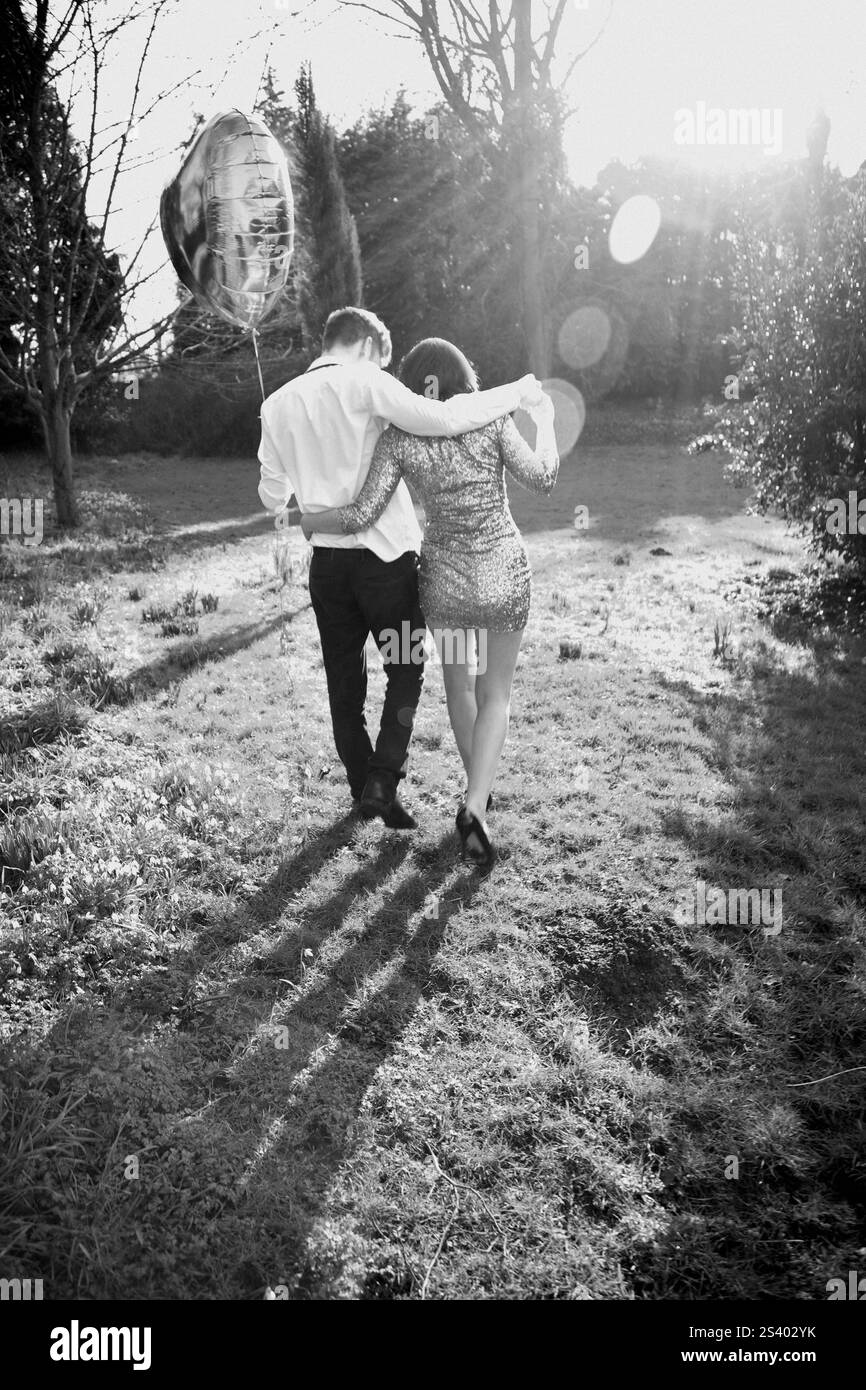 Couple in Park Holding Heart Shaped Balloon, Back View Stock Photo - Alamy