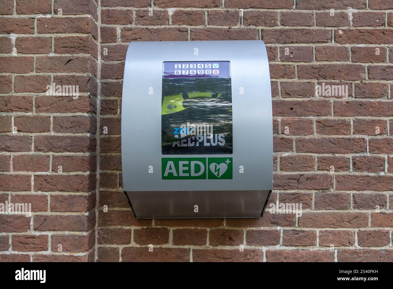 Geldrop, the Netherlands. 28 June 2024. City AED mounted on a stone brick wall. An AED, or automated external defibrillator, is used to help those exp Stock Photo