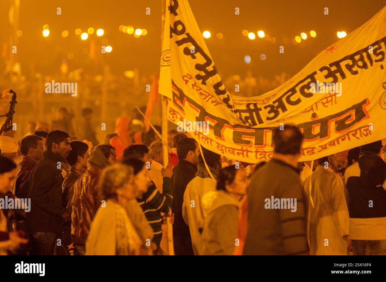 Crowd celebrating cultural festival at night with vibrant lights and traditional attire Stock Photo