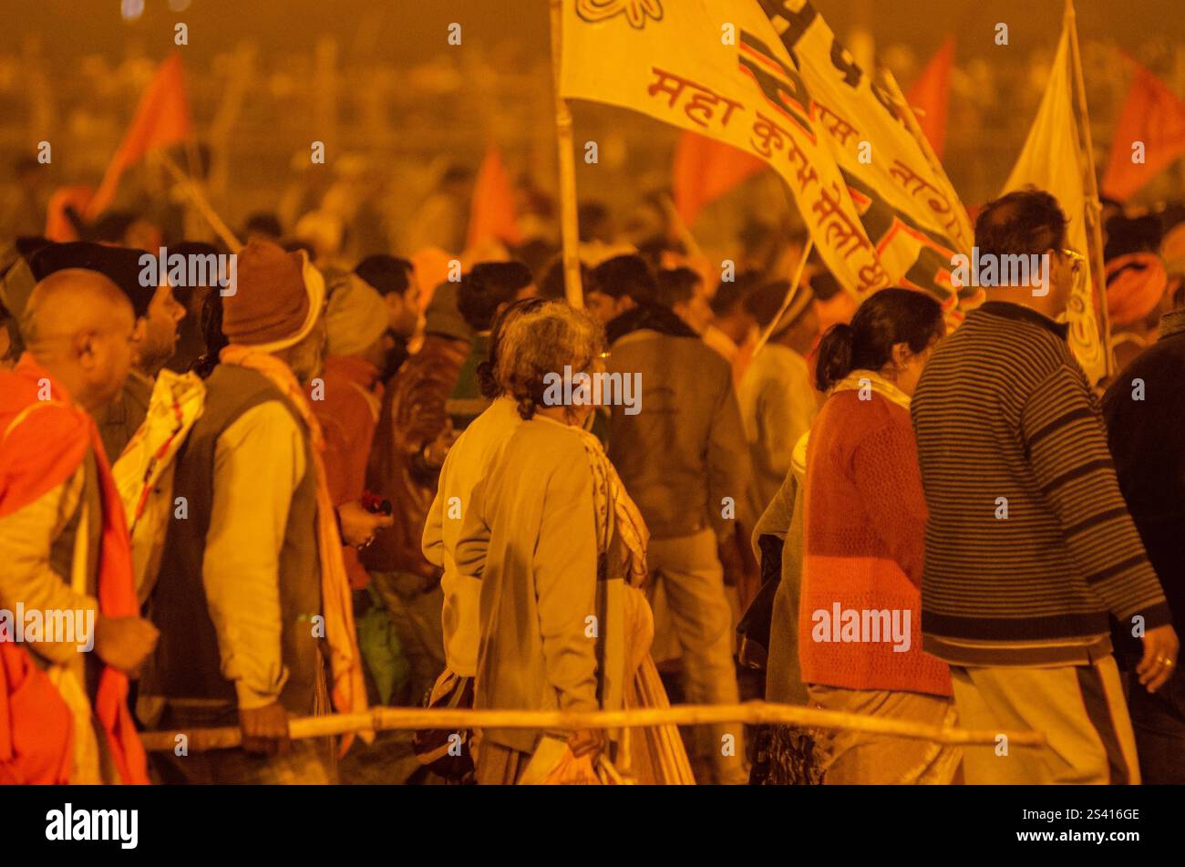 Crowd celebrating cultural festival at night with vibrant lights and traditional attire Stock Photo