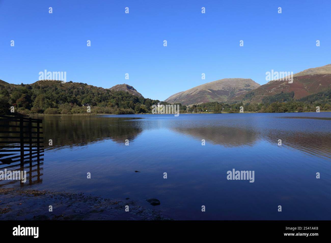 Blue Grasmere. The clear blue sky is reflected in the deeper blue water of this beautiful Lake in the lake District National Park. Stock Photo