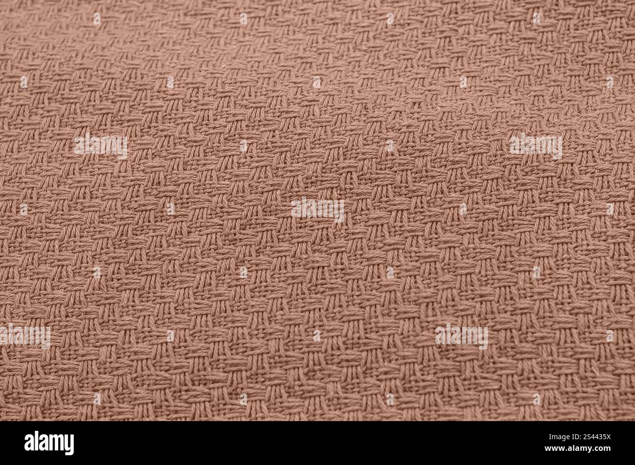 Close-up of intricately woven textured fabric in earthy brown shade. Stock Photo