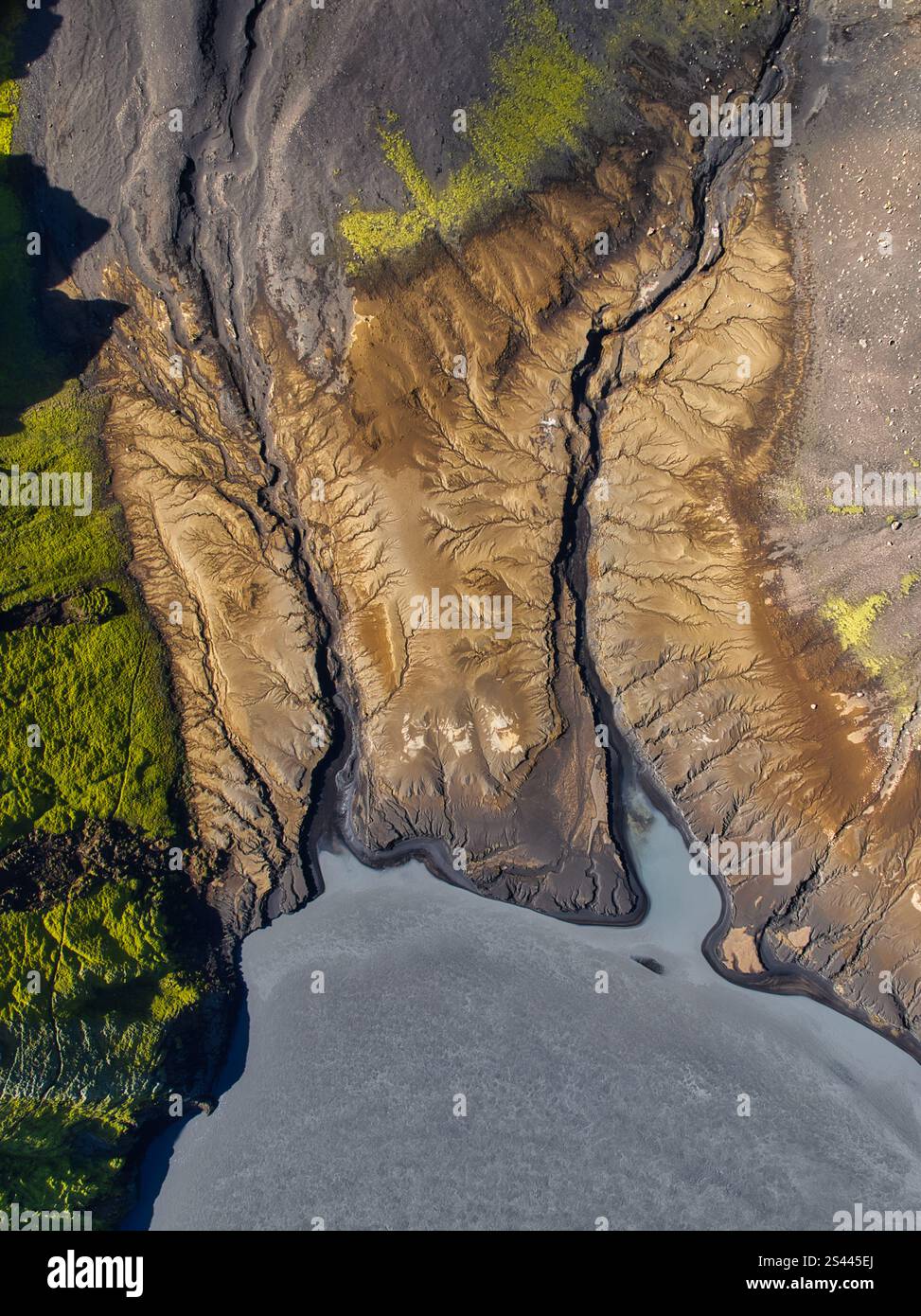 Aerial view of Icelandic canyons shaped by glacial erosion, showcasing dramatic textures, earthy tones, and green moss in a stunning natural landscape Stock Photo