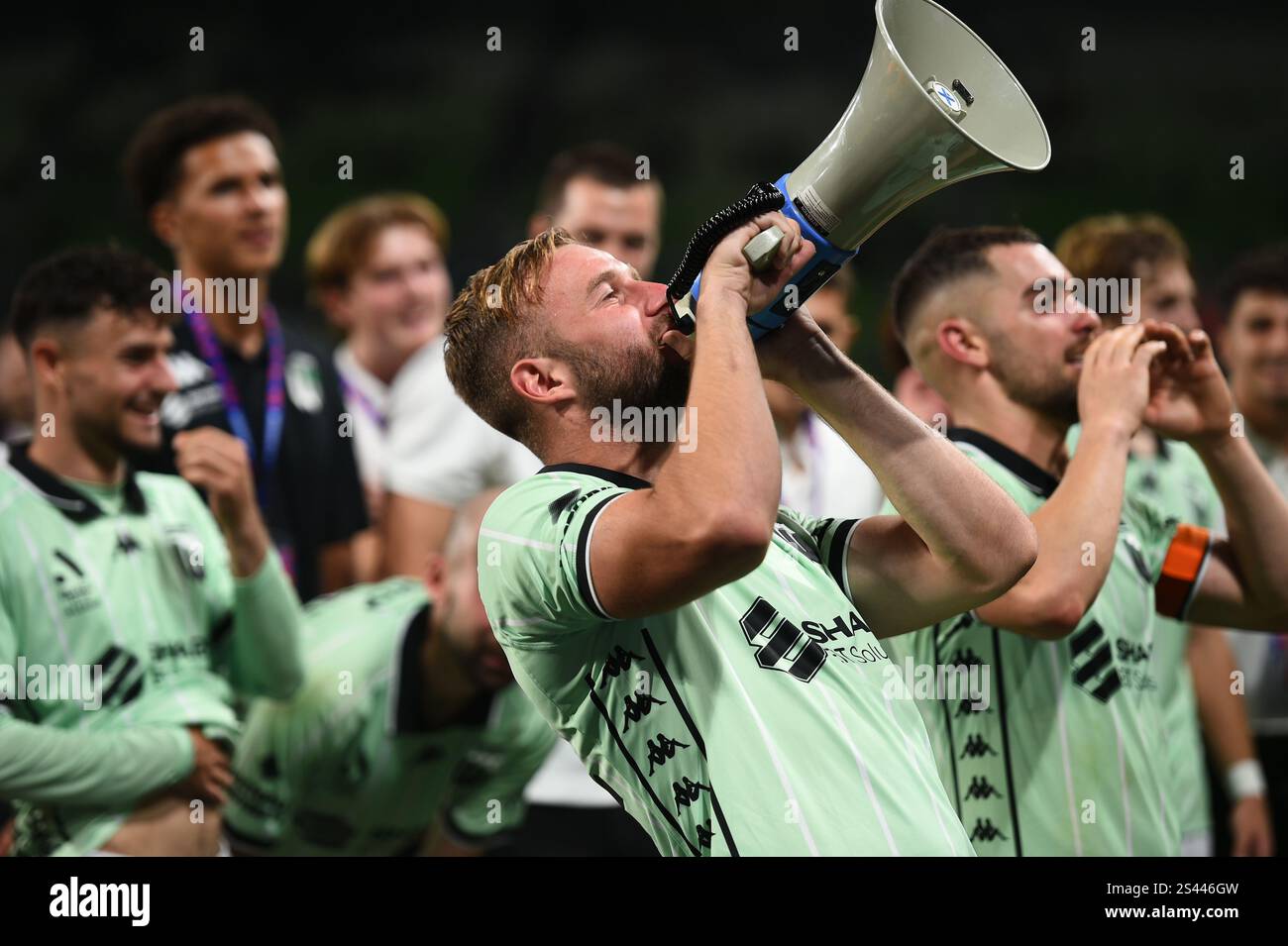 MELBOURNE, AUSTRALIA. 10th Jan 2025. Pictured: Western United forward Michael Ruhs chants into a megaphone and Ben Garuccio shouts towards the celebrating Western United travelling supporters after United secured 4-3 win at the end of the ISUZU A League Round 13 match, Melbourne Victory vs Western United at AAMI Park, Melbourne, Australia on 10th January 2025. Credit: Karl Phillipson / Alamy Live News Stock Photo