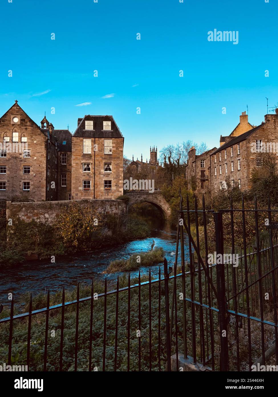 A picturesque scene in Dean Village, Edinburgh, with the Water of Leith flowing through the historic buildings. - Smartphone Captured Stock Image