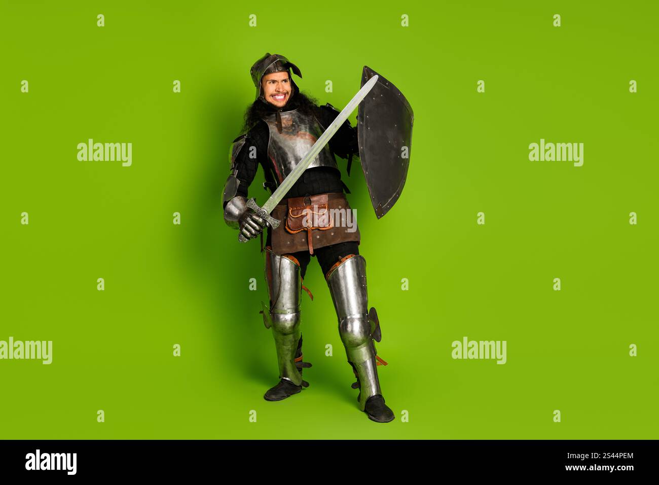 Medieval knight in armor holding sword and shield on green backdrop ...