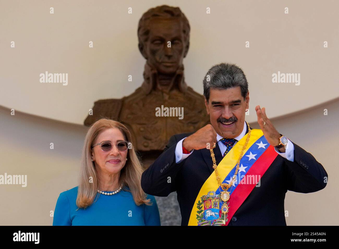 Venezuelan President Nicolas Maduro gestures to supporters next to his