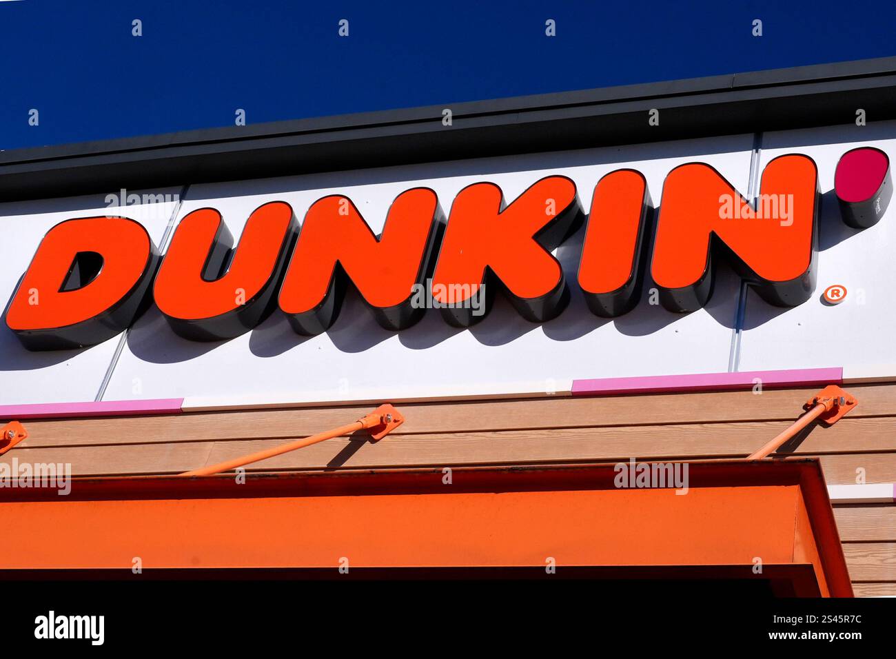 The Dunkin' name appears on a sign over the doorway at a Dunkin' donuts